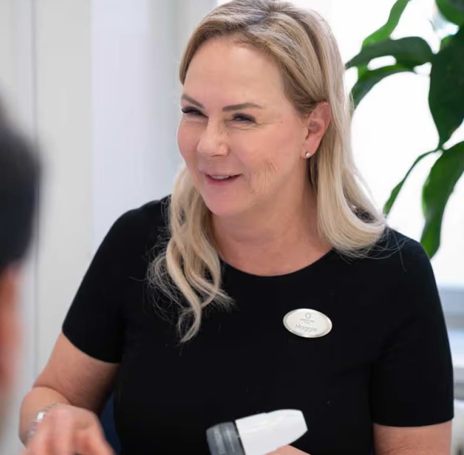 Leende medarbetare på Nordic Hair Clinic i samtal med en kund